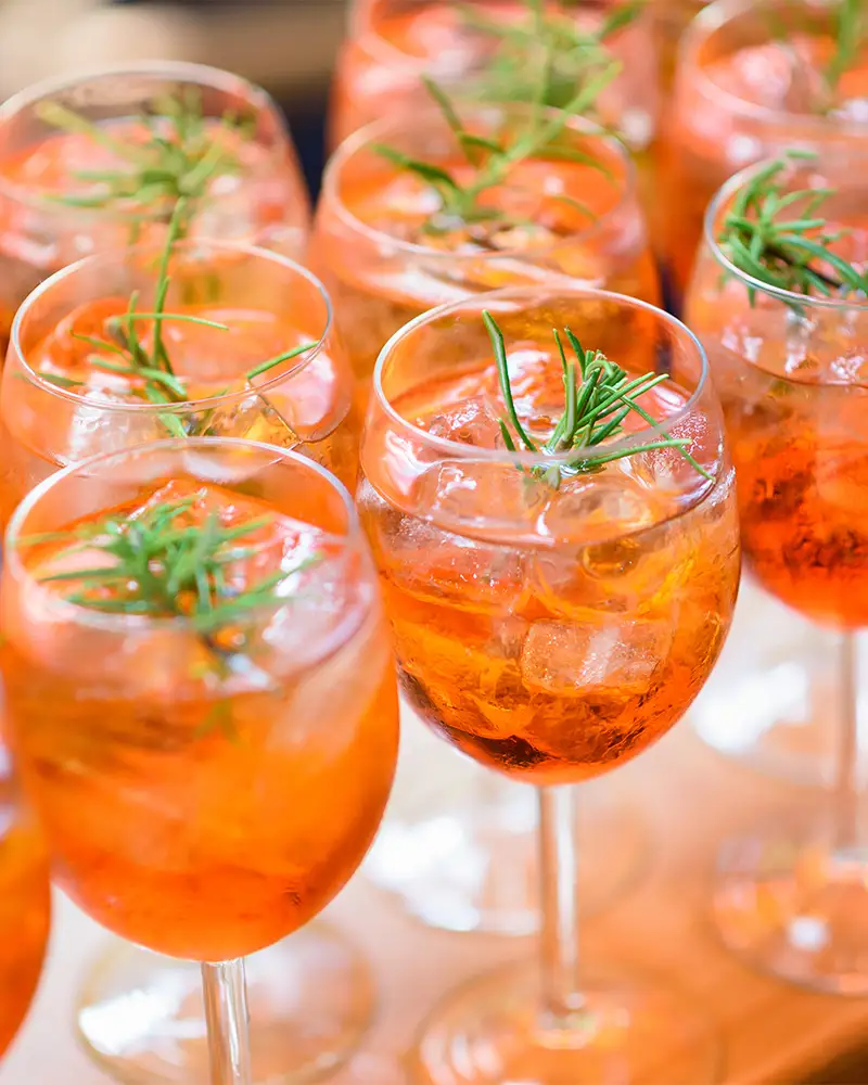 Mehrere Aperol Spritz in Gläsern nebeneinander angerichtet