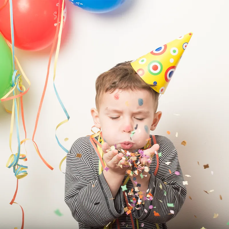 Junge bläst Confetti in die Luft